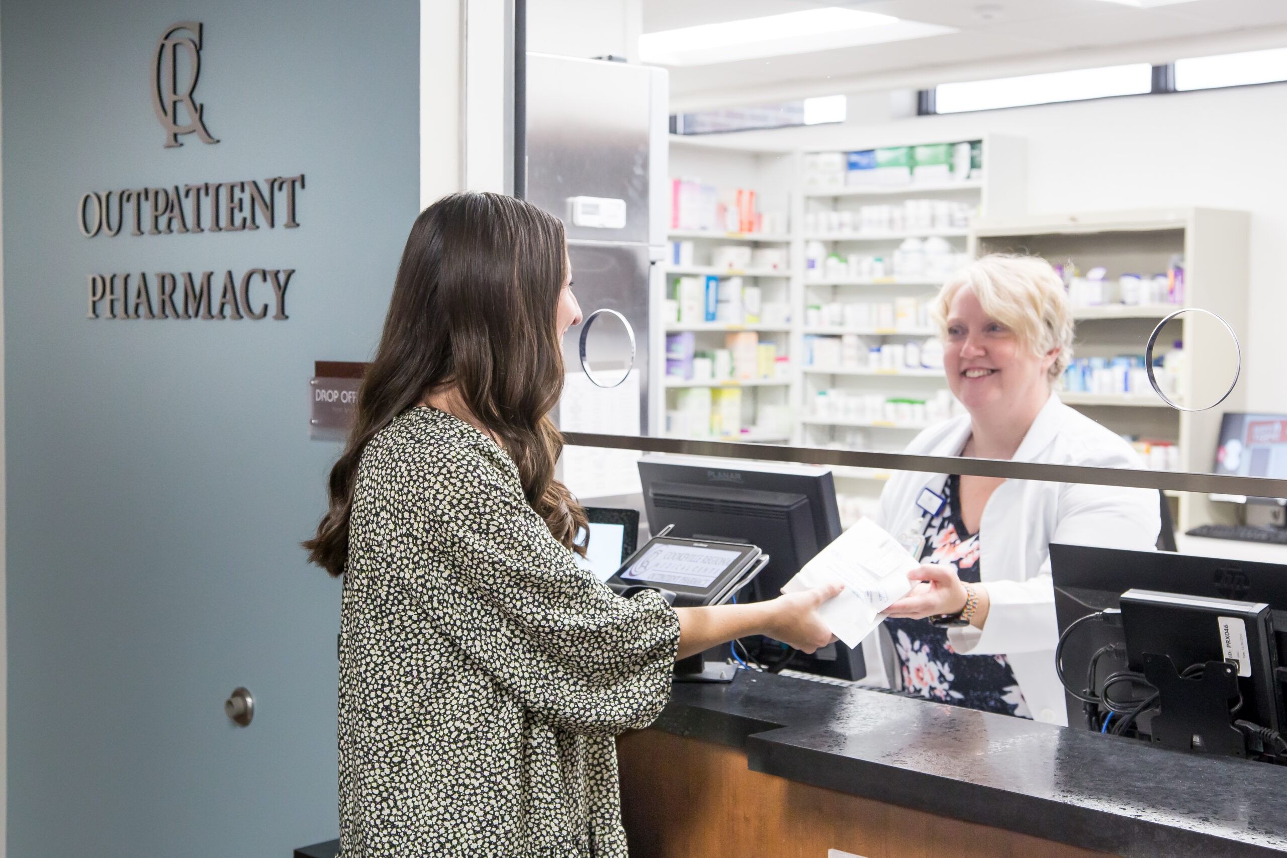 A customer picks up a prescription at CRMC’s Outpatient Pharmacy window.